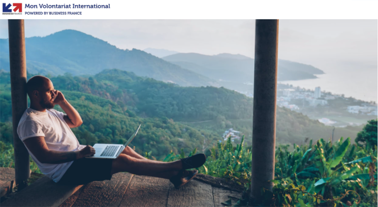 Logo volontariat international à l&#039;étranger puis un jeune homme et son ordinateur portable face un à panorama de mer et montagnes